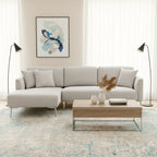 Modern living room with a gray sectional sofa, wooden coffee table, and abstract art on the wall.