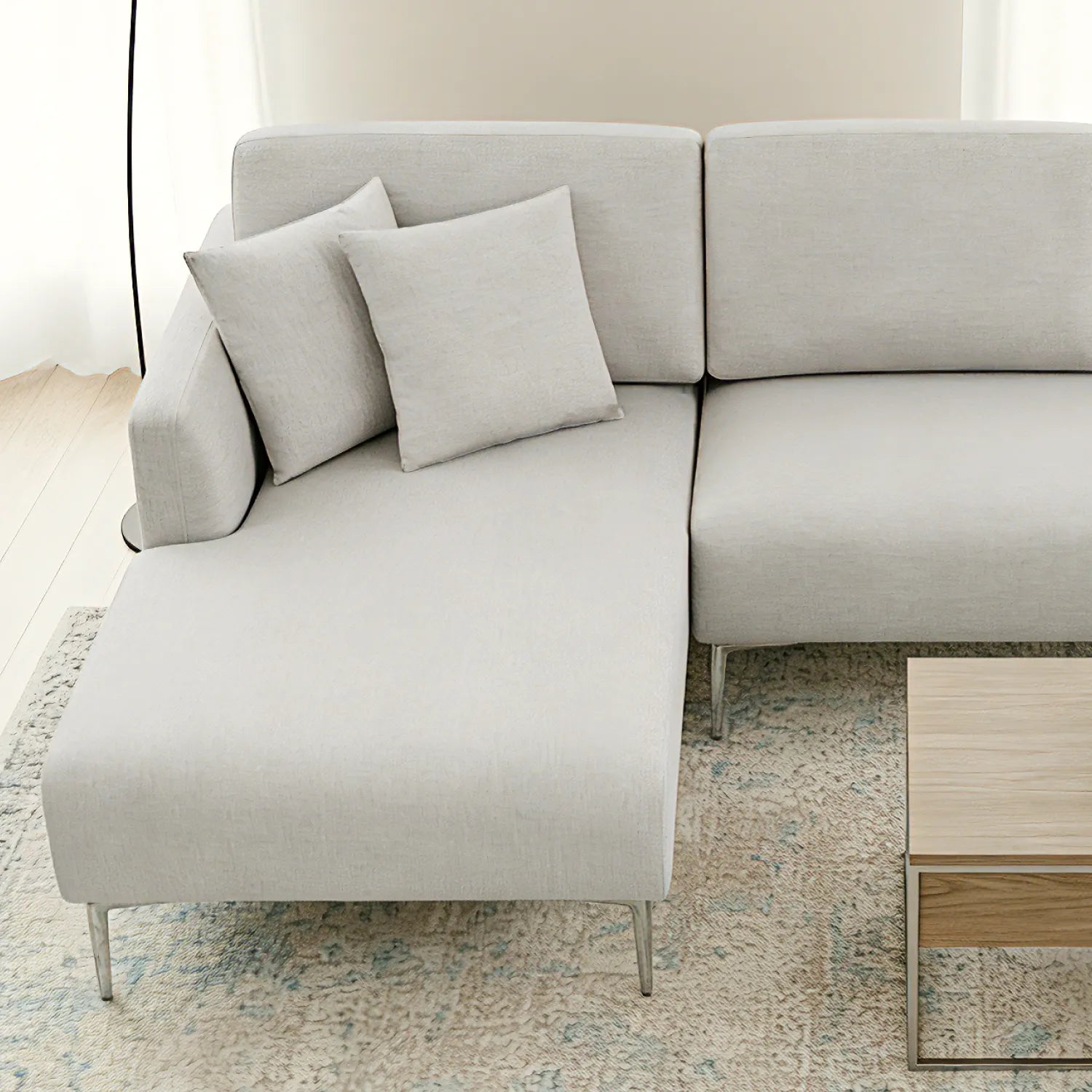 Light gray sectional sofa with cushions in a minimalistic room.
