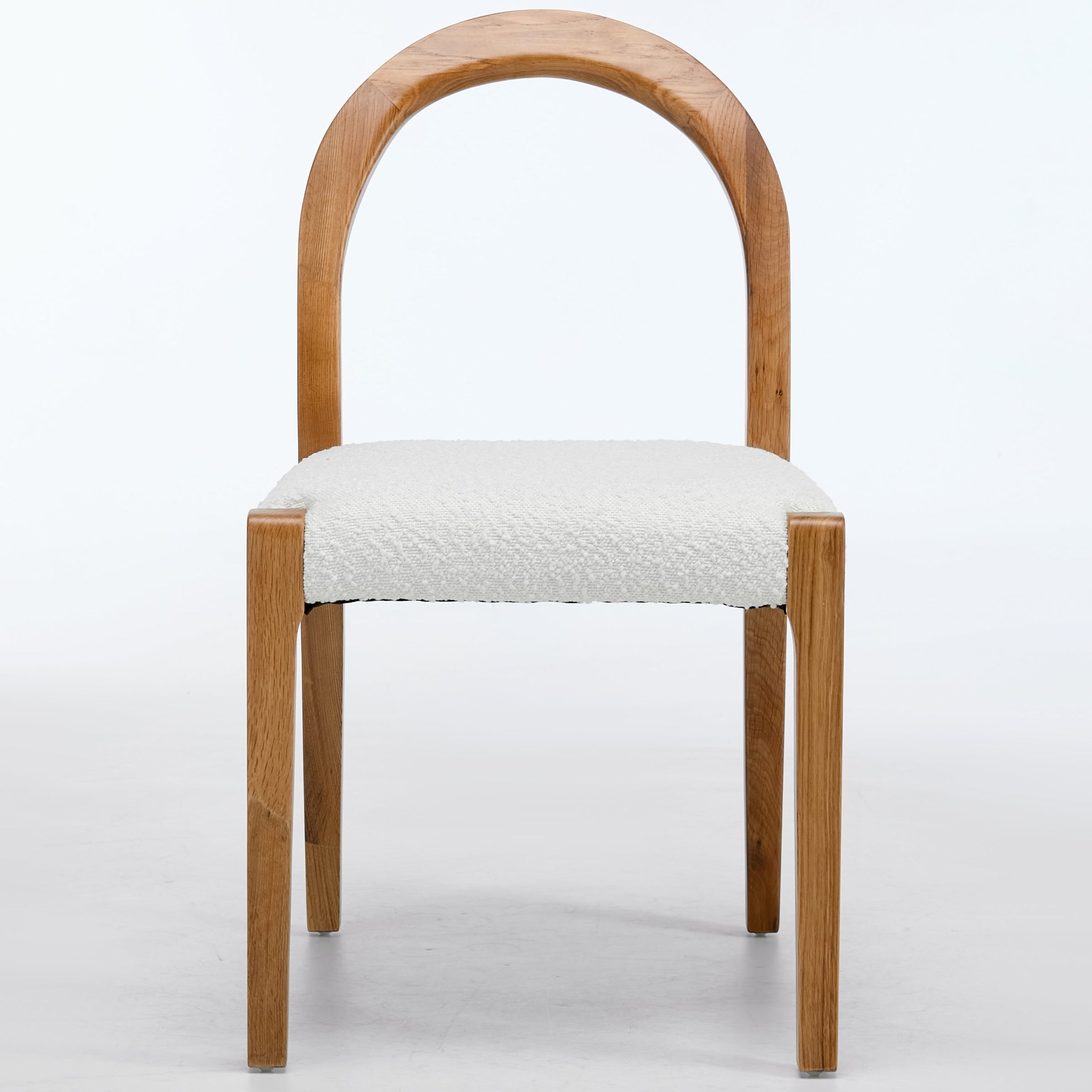 Wooden chair with a white cushioned seat on a light gray background