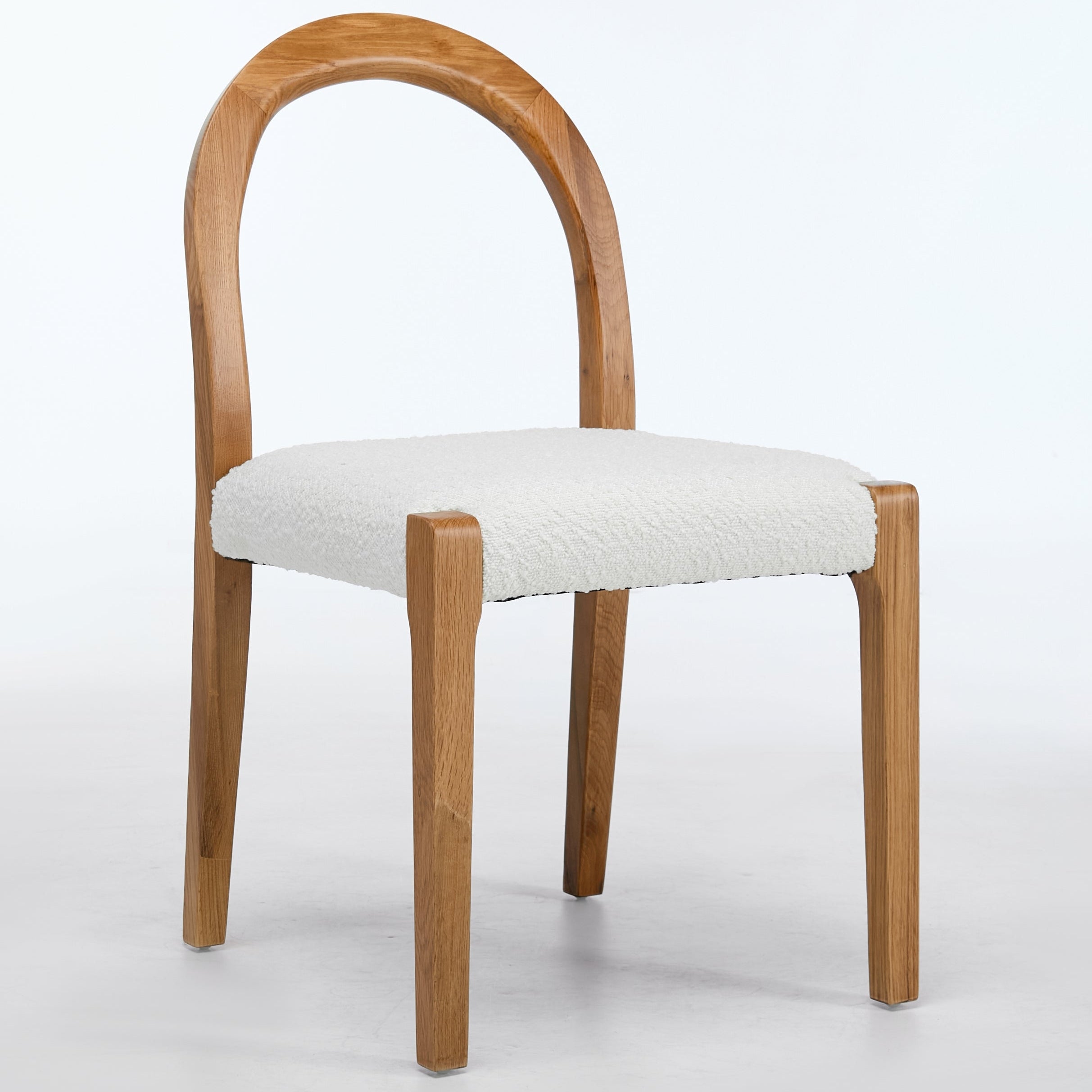 Wooden chair with a white cushion on a light gray background