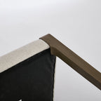 Corner of a piece of furniture with wooden armrest and fabric seat on a white background