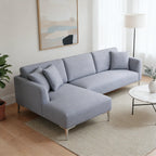 Gray sectional sofa in a living room with a plant and coffee table.