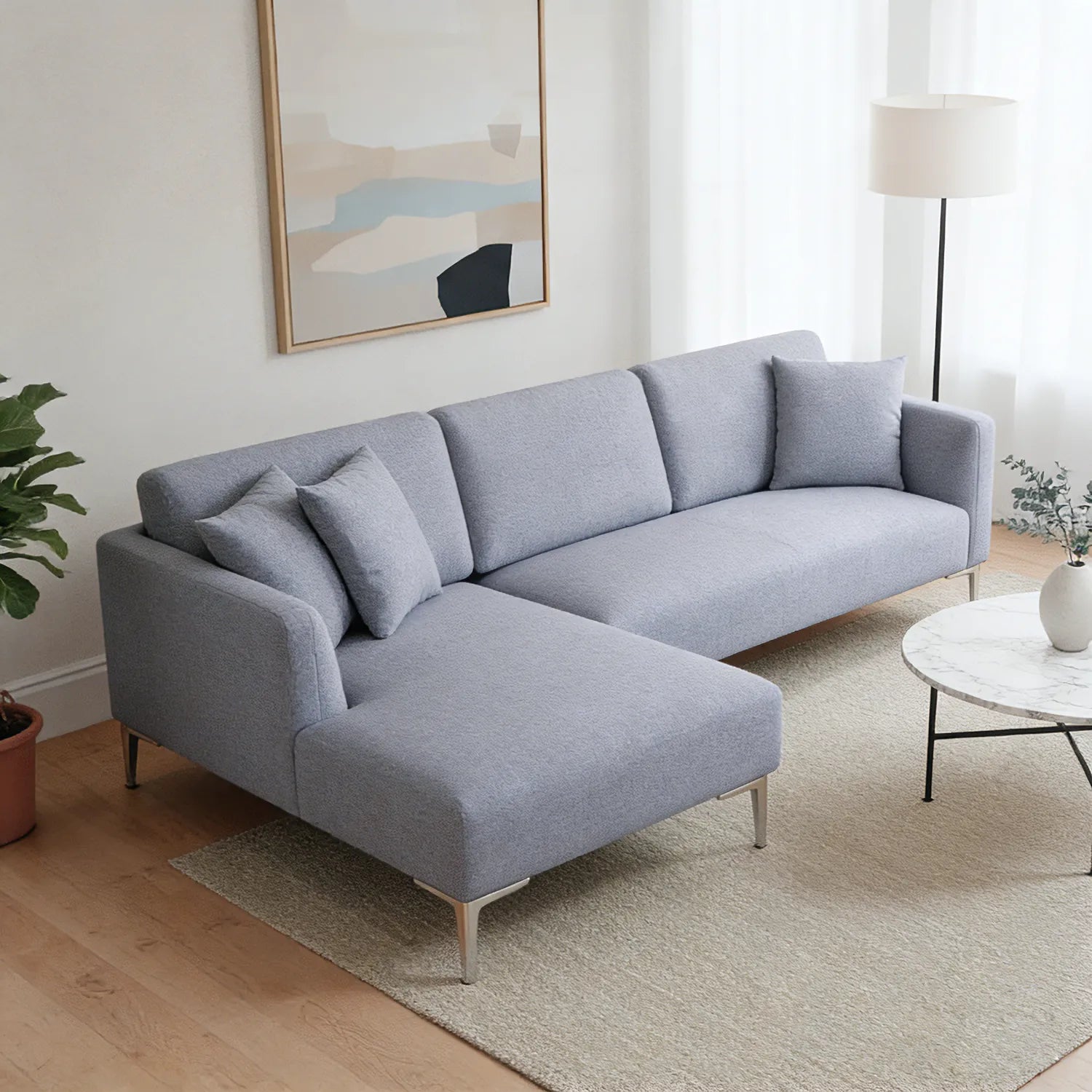 Gray sectional sofa in a living room with a plant and coffee table.